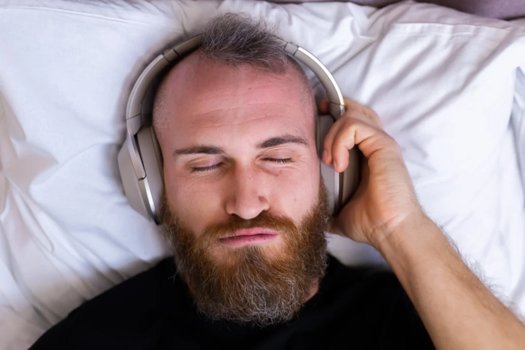 un homme qui écoute des sons binauraux avec un casque.